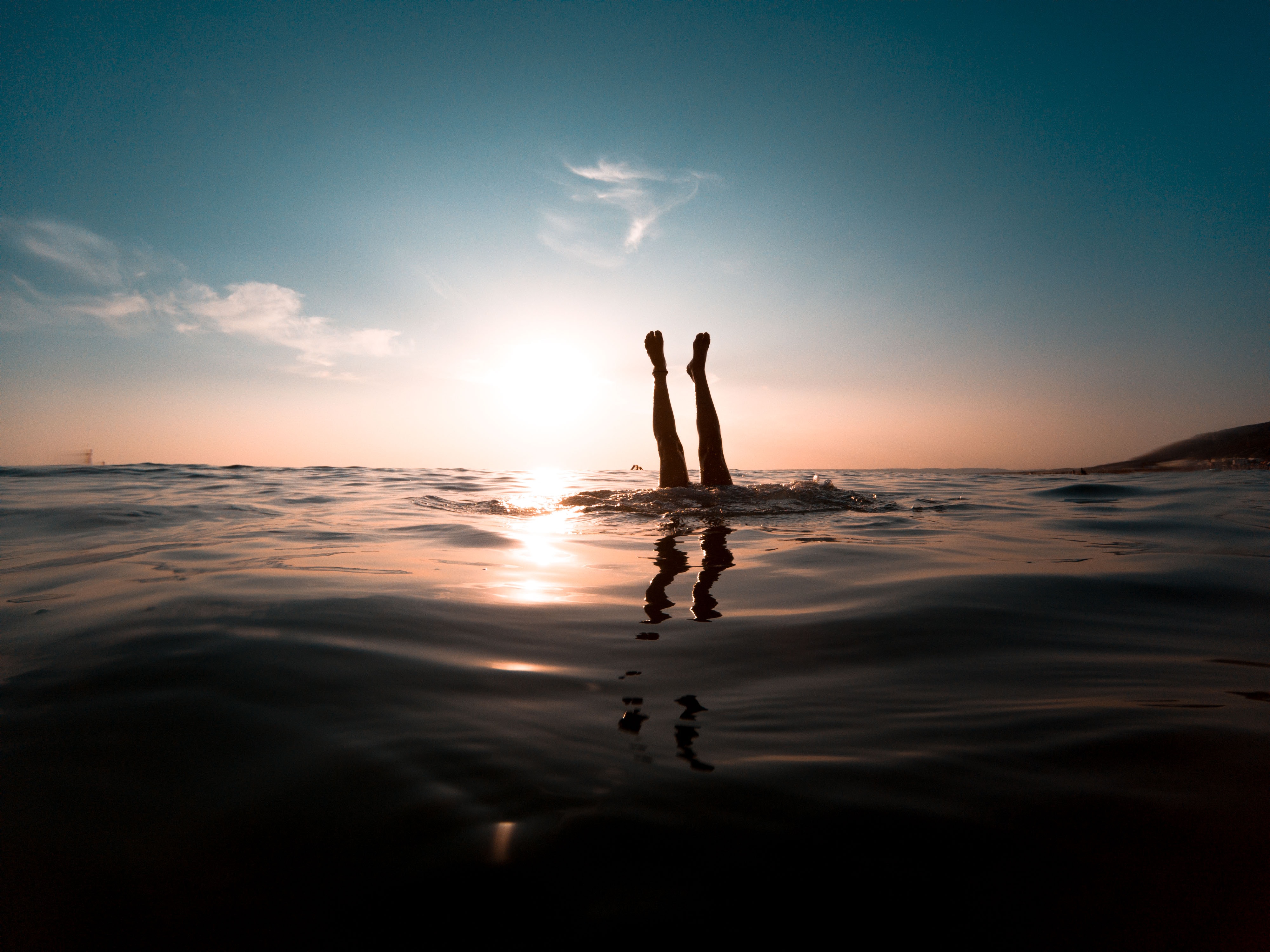 Photograph of someone doing a handstand in the sea